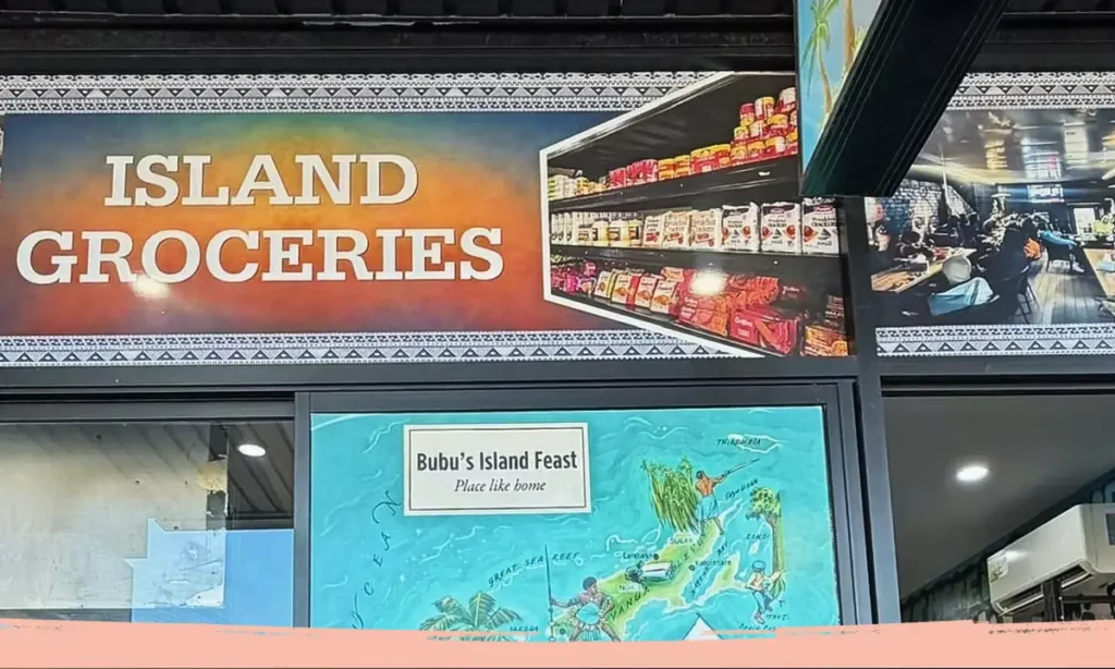 Shopfront signs for Island Groceries and Bubu's Island Feast in Granville, above a painted map of Fiji