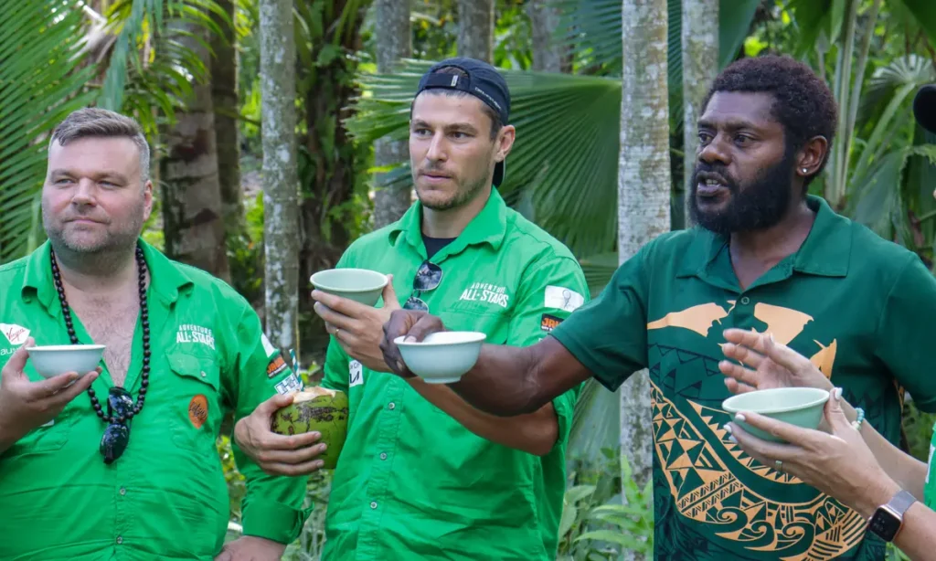 Guests in green shirts sampling kava from bowls at Eden on the River in Port Vila