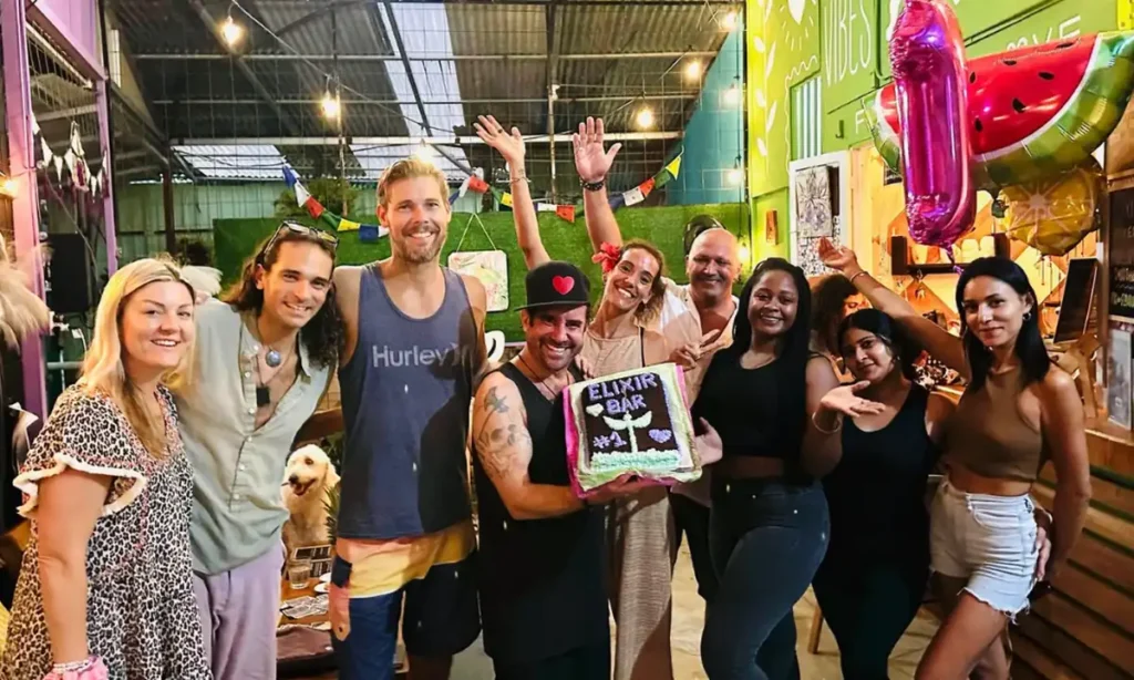 Guests and staff celebrating with a cake at Elixir Bar in Jacó, Costa Rica