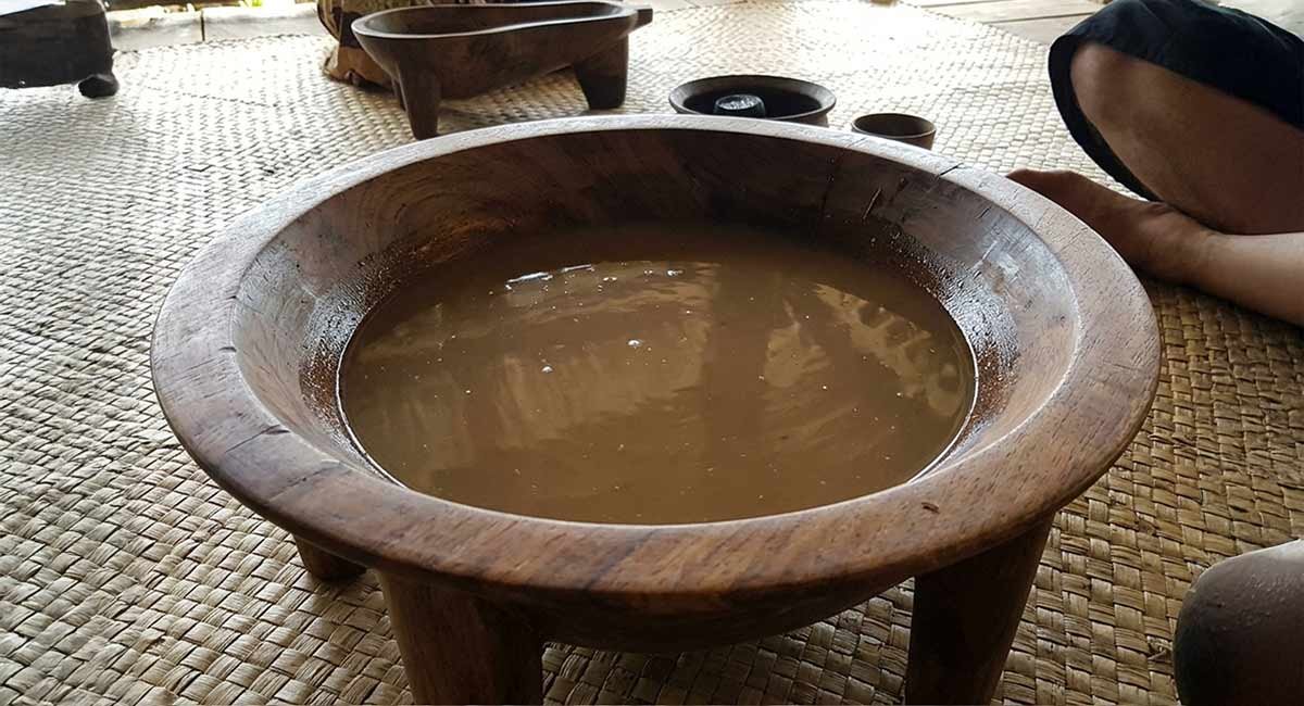 Finished kava drink served in a traditional carved tanoa bowl